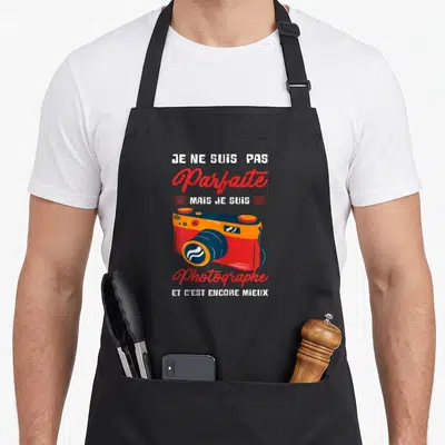 Tablier de cuisine noir avec une caméra vintage rouge et le texte Je ne suis pas parfaite mais je suis photographe.