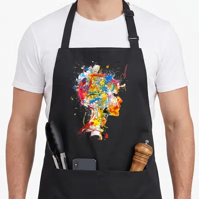 Tablier de cuisine noir avec un portrait féminin abstrait aux couleurs vives et aux éclats de peinture.