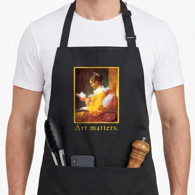 Tablier de cuisine noir avec une reproduction encadrée d'une femme lisant et le texte Art matters en dessous.