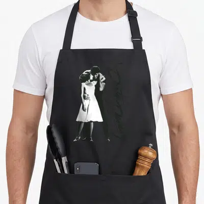 Tablier de cuisine noir avec une illustration vintage en noir et blanc représentant un couple dansant et le titre du film écrit en calligraphie.