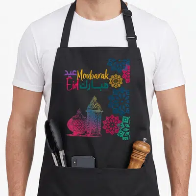 Tablier de cuisine noir avec lanternes colorées, mandalas arabesques et texte Eid Moubarak bilingue.