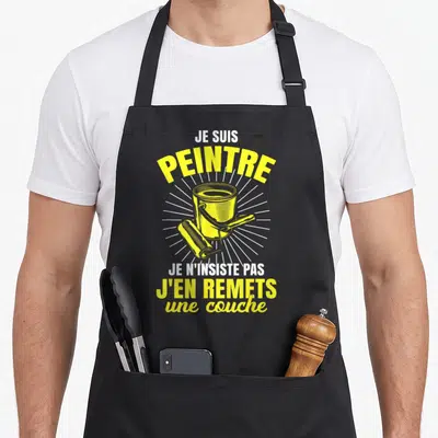 Tablier de cuisine noir avec illustration jaune d'un pot de peinture et d'un rouleau, entouré de rayons blancs.
