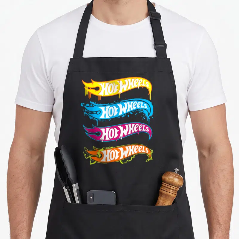 Tablier de cuisine noir avec quatre logos Hot Wheels multicolones stylisés en flammes et peinture giclée.
