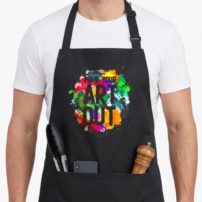 Tablier de cuisine noir avec éclaboussures de couleurs vives et texte Versez votre art out en gris central.