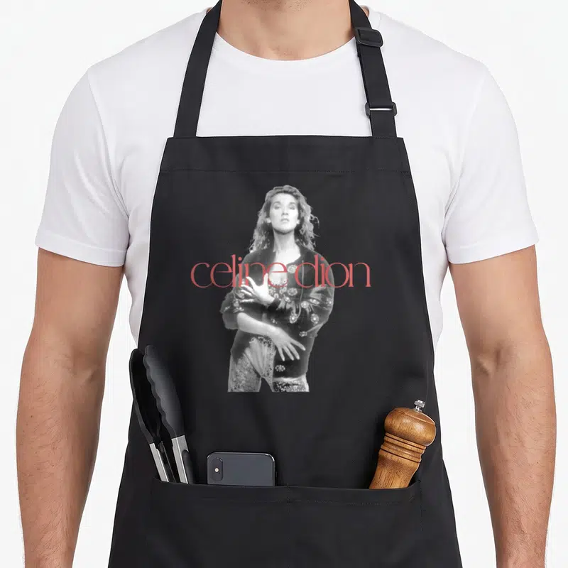 Tablier de cuisine noir avec portrait noir et blanc de Celine Dion et texte rouge celine dion superposé.