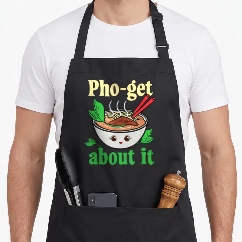 Tablier de cuisine noir avec illustration d'un bol de pho souriant et paires de baguettes rouges