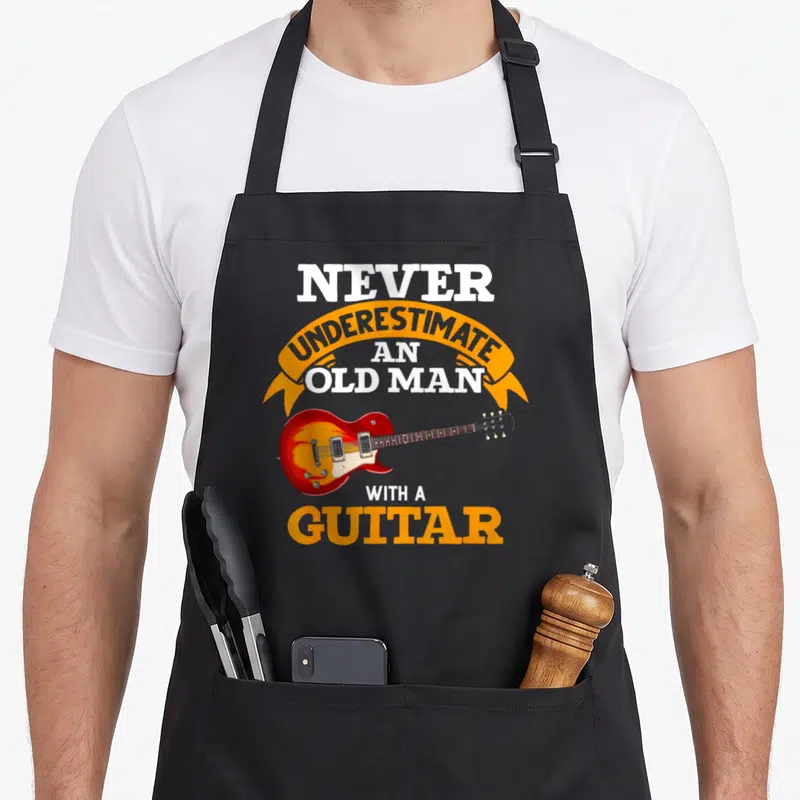 Tablier de cuisine noir avec illustration de guitare électrique rouge et texte blanc orange Never Underestimate an Old Man with a Guitar