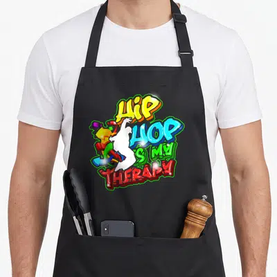 Tablier de cuisine noir avec un motif graffiti coloré affichant Hip Hop is my Therapy et une silhouette blanche.