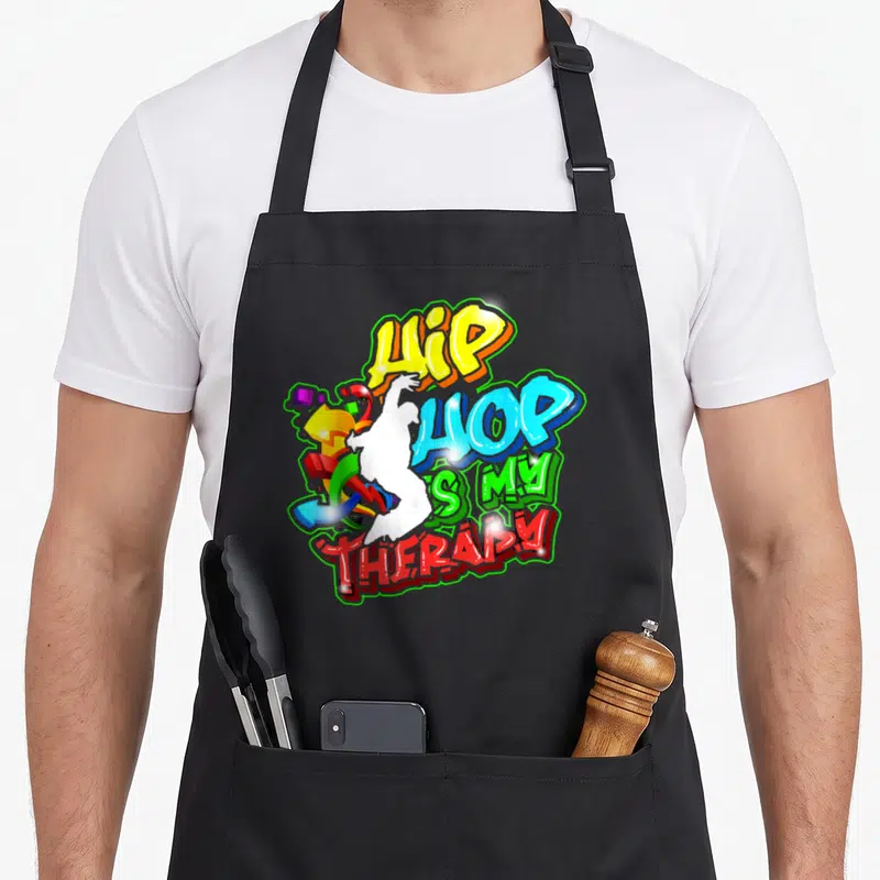 Tablier de cuisine noir avec un motif graffiti coloré affichant Hip Hop is my Therapy et une silhouette blanche.