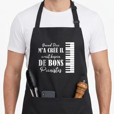 Tablier de cuisine noir avec inscription blanche sur la musique et dessin de touches de piano verticales.