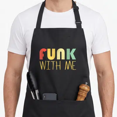 Tablier de cuisine noir avec l'inscription Funk With Me en typographie vintage multicolore rouge jaune et vert menthe.