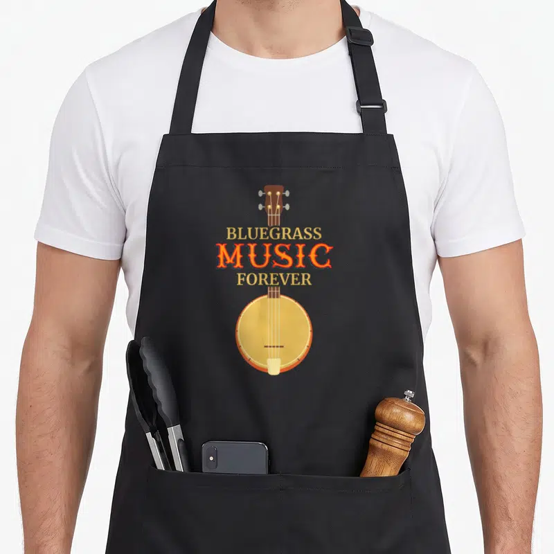 Tablier de cuisine noir avec illustration de banjo et texte Bluegrass Music Forever en orange et jaune doré.