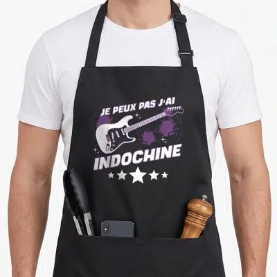 Tablier de cuisine noir avec une guitare électrique blanche, le texte Je peux pas j'ai Indochine et cinq étoiles blanches.