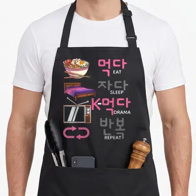 Tablier de cuisine noir avec illustration d'un lit, d'un téléviseur et mots Eat Sleep K-drama Repeat en coréen et anglais.
