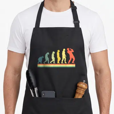 Tablier de cuisine noir avec une illustration colorée représentant l'évolution humaine en silhouette jusqu'à un musicien jouant du saxophone.