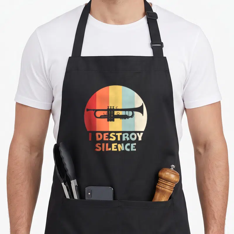 Tablier de cuisine noir avec illustration de trompette sur fond arc-en-ciel et texte I Destroy Silence en lettres multicolores.