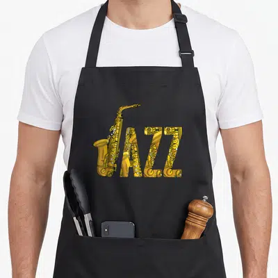 Tablier de cuisine noir avec illustration d'un saxophone jaune formant le mot JAZZ en typographie stylisée.