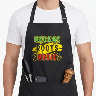 Tablier de cuisine noir avec l'inscription Reggae Roots Music aux couleurs vert jaune et rouge et notes de musique jaunes.