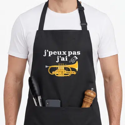 Tablier de cuisine noir avec inscription blanche et illustration de cornet à pistons jaune pointé par une main.