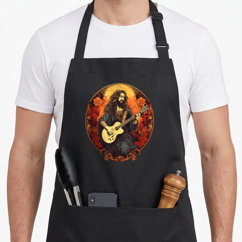 Tablier de cuisine noir avec une illustration d'un guitariste aux longs cheveux entouré de motifs floraux orange et rouge.