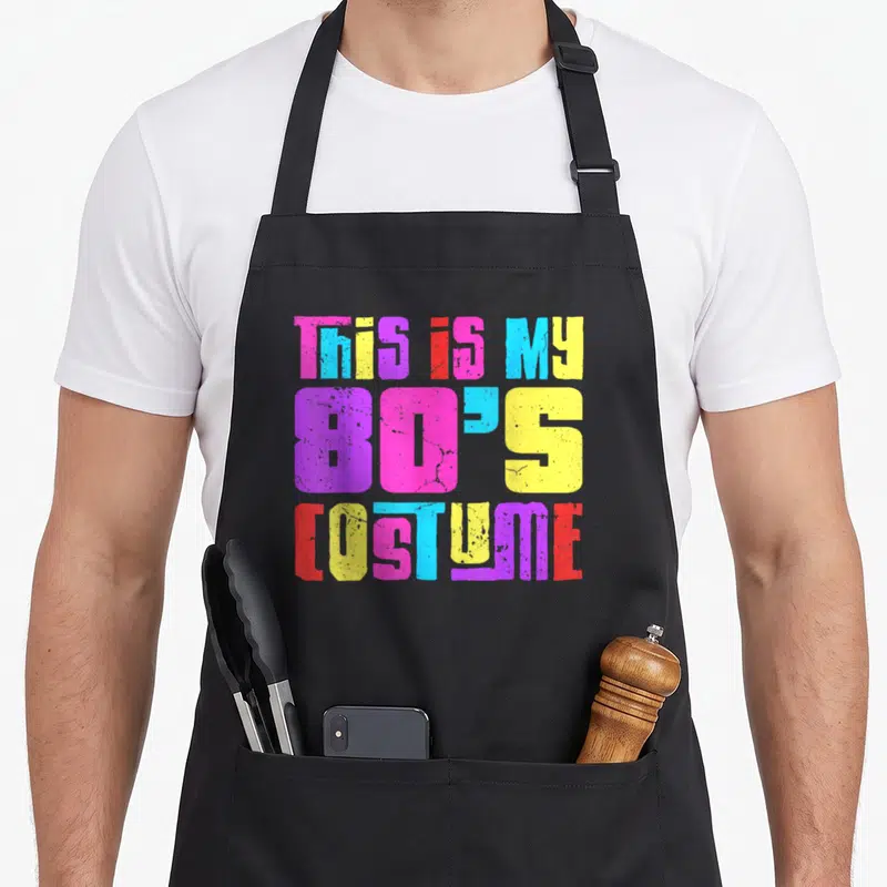 Tablier de cuisine noir avec inscription This is my 80s costume en typographie multicolore et effet dégradé vintage.