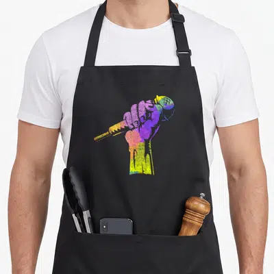 Tablier de cuisine noir avec illustration d'une main colorée tenant un microphone de style graffiti.