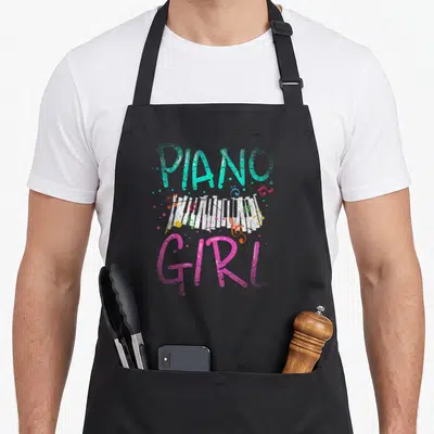Tablier de cuisine noir avec inscription Piano Girl et claviers illustrés multicolores.
