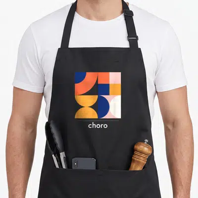 Tablier de cuisine noir avec un motif géométrique aux couleurs vives et le mot choro en bas.