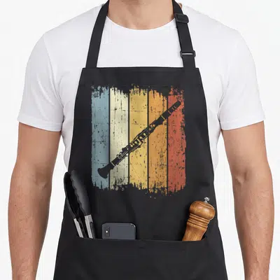 Tablier de cuisine noir avec illustration clarinette rétro sur fond de bandes bleu jaune orange et rouge texturées.
