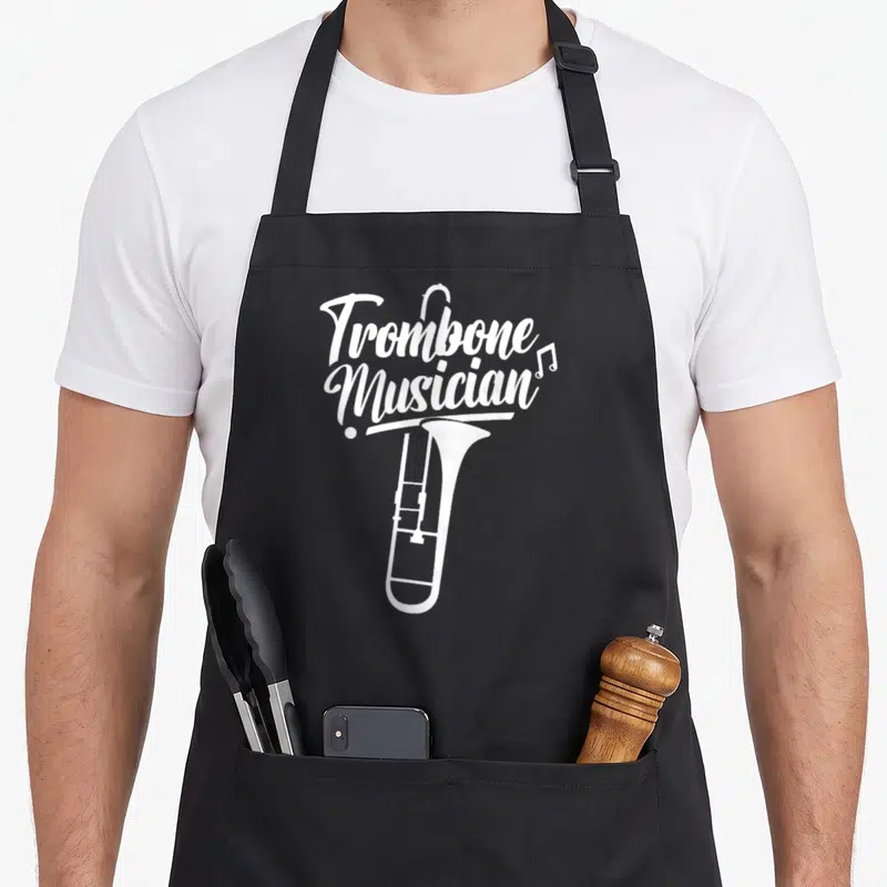 Tablier de cuisine noir avec illustration blanche d'un trombone et du texte Trombone Musician en calligraphie.
