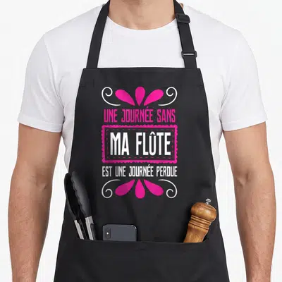 Tablier de cuisine noir avec inscription rose et blanche Une journée sans ma flûte est une journée perdue entourée de motifs décoratifs.