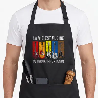 Tablier de cuisine noir avec cinq guitares électriques colorées et texte blanc La vie est pleine de choix importants