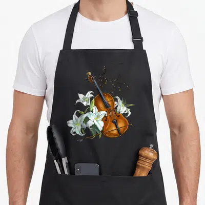 Tablier de cuisine noir avec illustration d'un violon, de lys blancs et de portées musicales dorées.