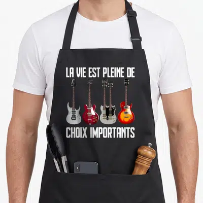 Tablier de cuisine noir avec quatre guitares électriques et le texte la vie est pleine de choix importants
