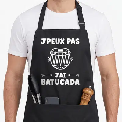 Tablier de cuisine noir avec l'inscription J'peux pas j'ai batucada et un dessin de tambour blanc au centre.