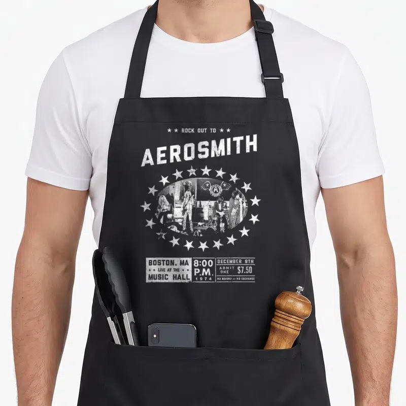 Tablier de cuisine noir avec illustration vintage du groupe Aerosmith et des étoiles blanches.