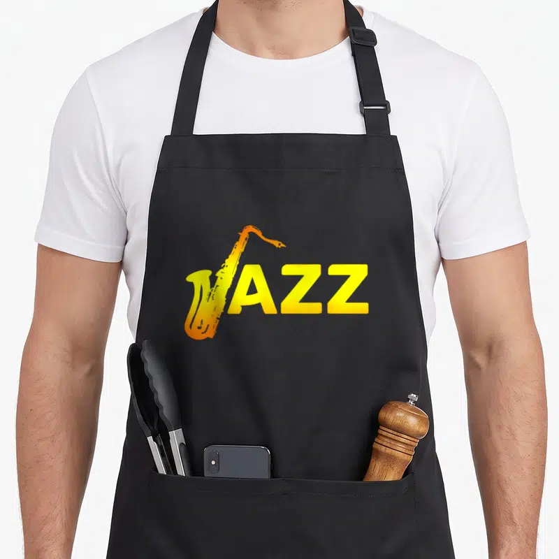 Tablier de cuisine noir avec un saxophone orange intégrant le mot JAZZ en lettres jaunes.