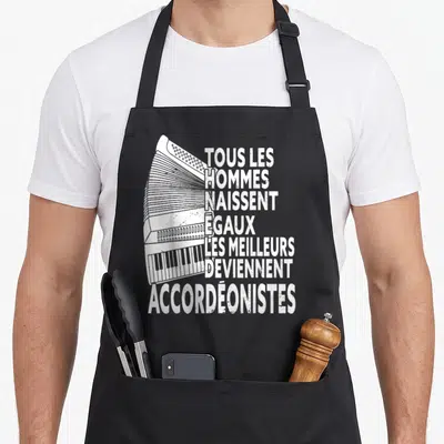 Tablier de cuisine noir avec illustration d'accordéon et texte blanc tous les hommes naissent égaux accordéonistes