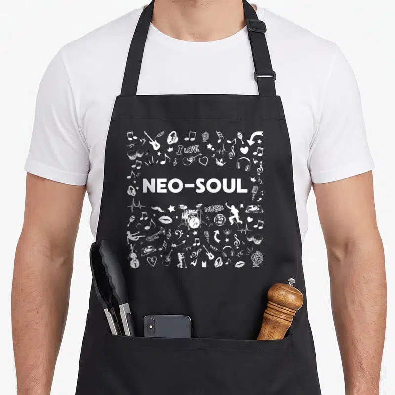 Tablier de cuisine noir avec motifs blancs représentant des notes, des instruments et le texte Neo-Soul au centre.