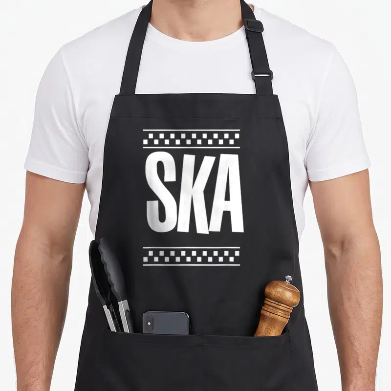 Tablier de cuisine noir avec linscription SKA en blanc et des motifs géométriques rectangulaires au-dessus et en dessous.