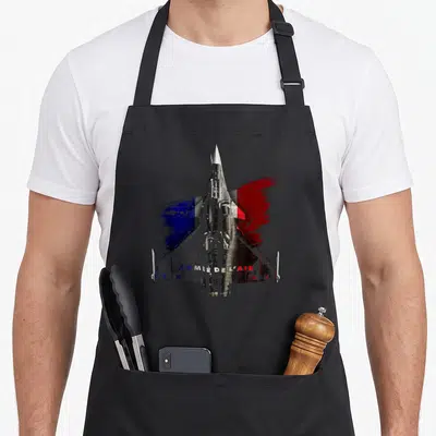 Tablier de cuisine noir avec avion Rafale vue de dessus et drapeau français en arrière-plan texturé.