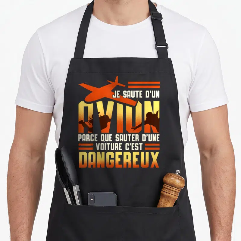 Tablier de cuisine noir avec illustration orange et texte blanc sur le parachutisme humoristique.