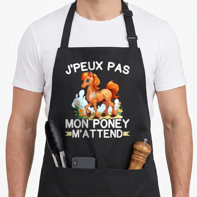 Tablier de cuisine noir avec un poney orange dessiné et le texte Je peux pas mon poney m'attend en blanc.