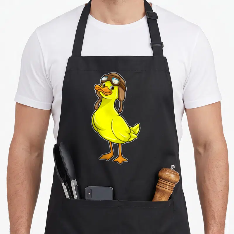 Tablier de cuisine noir avec illustration d'un canard jaune portant un casque de pilote en cuir marron et des lunettes de vol.