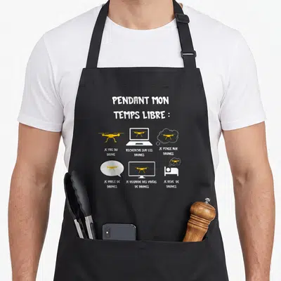 Tablier de cuisine noir avec texte blanc et icônes jaunes représentant la passion du drone dans la vie quotidienne.