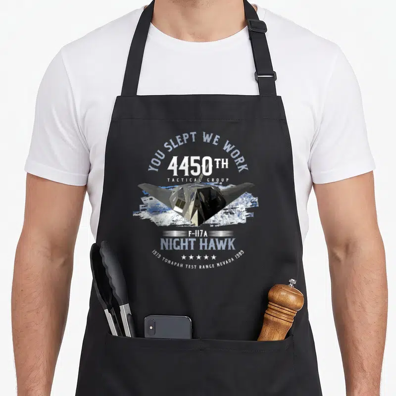 Tablier de cuisine noir avec illustration du F-117A Night Hawk et texte You Slept We Work 4450th Tactical Group