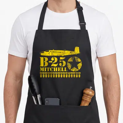 Tablier de cuisine noir avec illustration jaune d'avion B-25 Mitchell, étoile et bombes alignées.