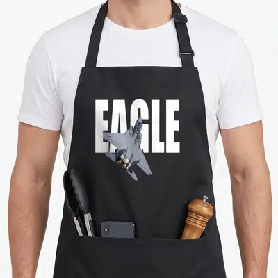 Tablier de cuisine noir avec illustration d'un avion F15 Eagle et le mot EAGLE en grandes lettres blanches.