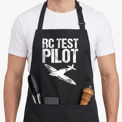 Tablier de cuisine noir avec inscription RC Test Pilot et illustration d'avion de combat blanc en vol incliné.