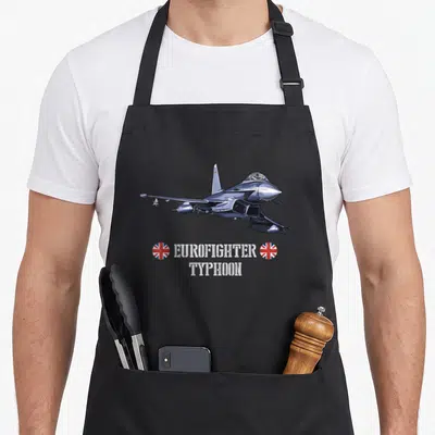 Tablier de cuisine noir avec illustration d'un avion Eurofighter Typhoon et des drapeaux britanniques circulaires sous le texte imprimé.